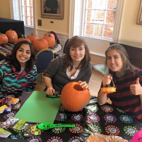 Three students carving pumpkins